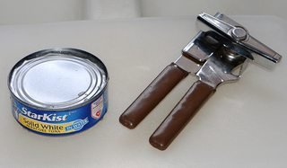 can of tuna with lid cut free with a can opener next to it